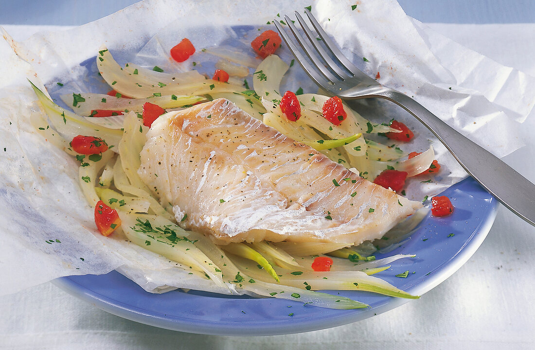 Cod fillet with fennel in parchment on plate