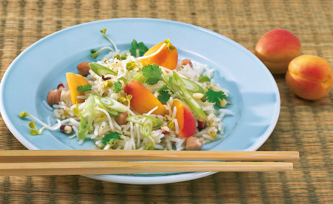 Rice salad with ginger, apricots and sprouts on plate