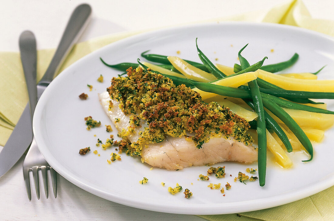 Close-up of zander fillet with herb crust and green beans on plate
