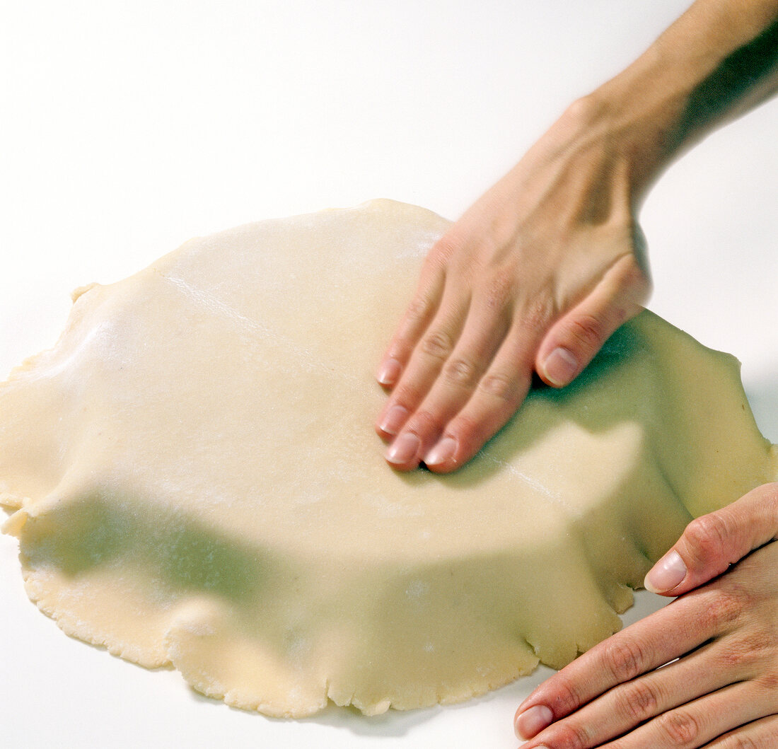 Close-up of hand smoothening marzipan on surface, step 2