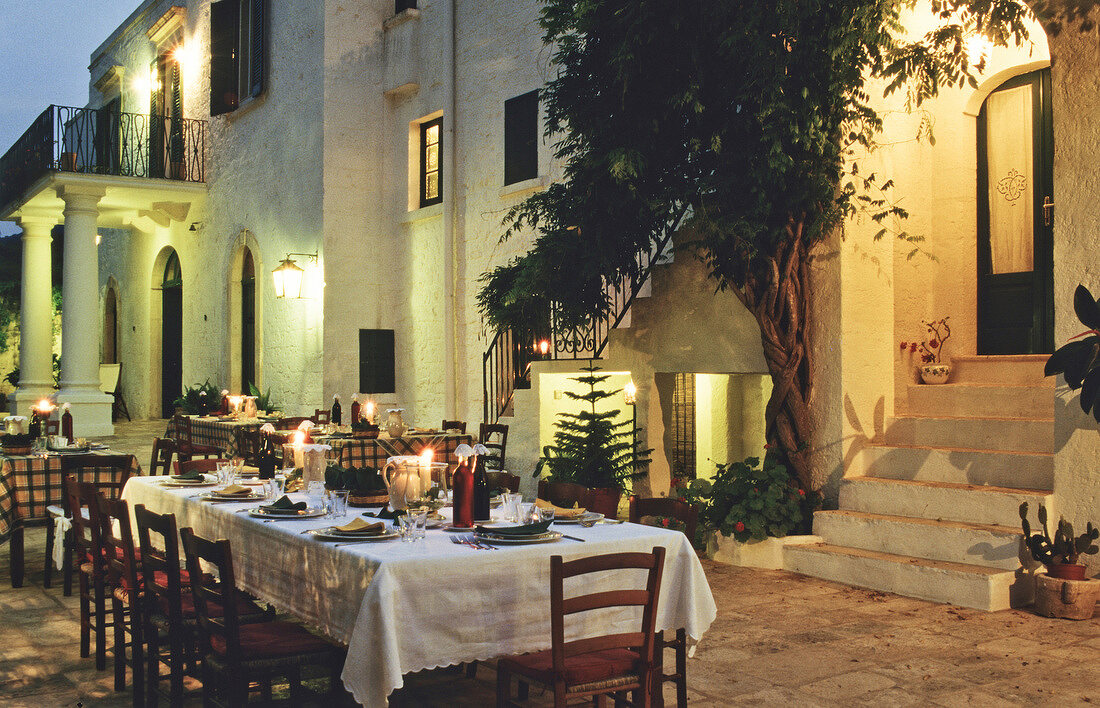 Laid tables in the courtyard of Italian restaurant at evening