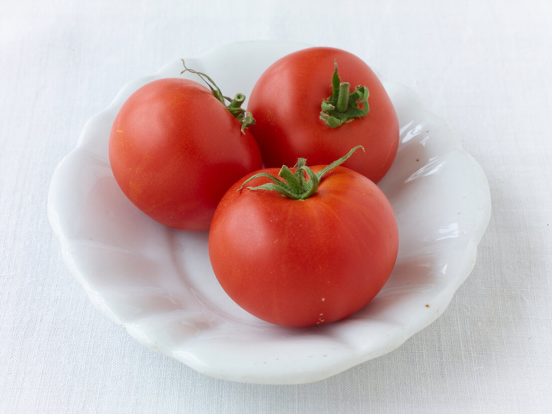 Close-up of three red tomatoes on plate, Oldendorfer