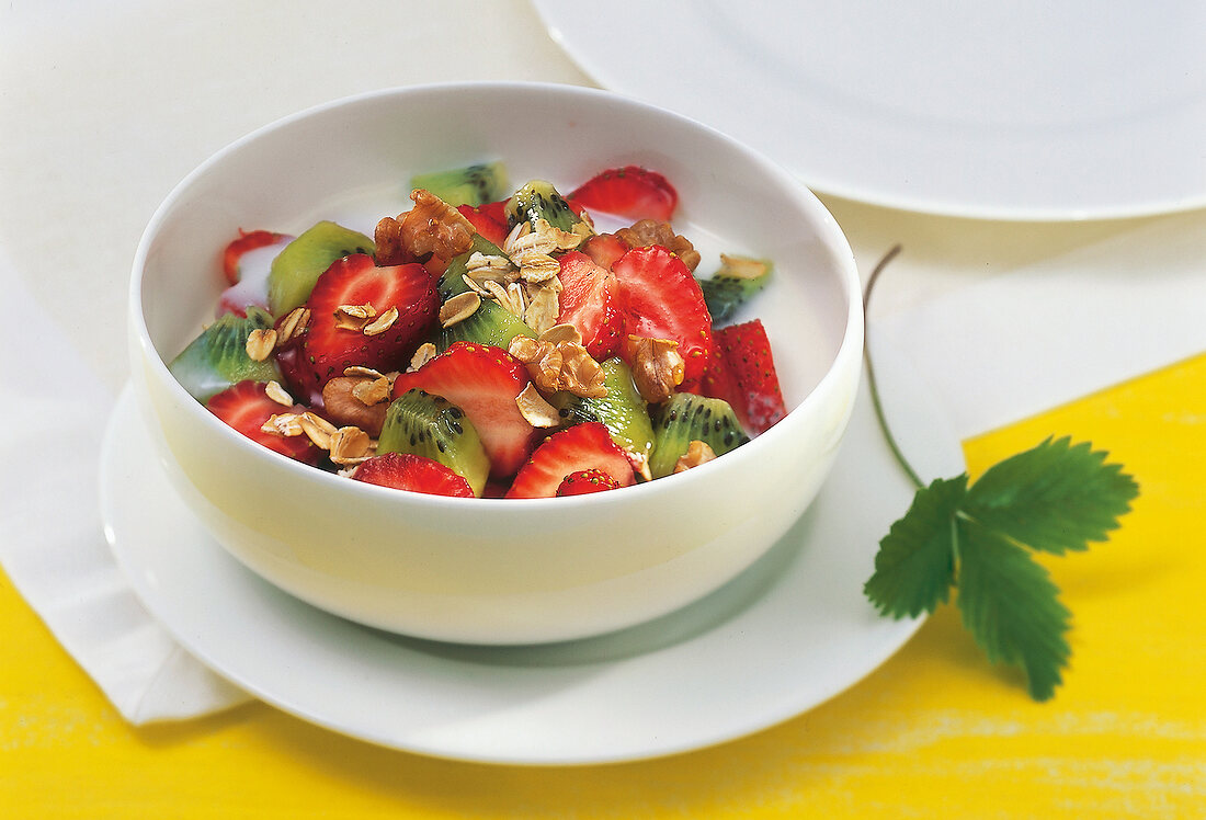 Strawberry-kiwi cereal with walnuts in bowl