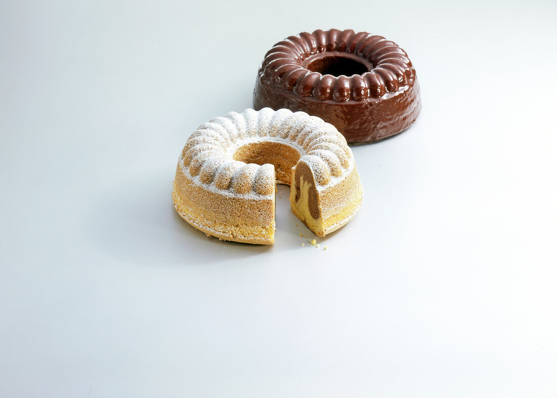 Two chocolate pound cake in ring shape on white background