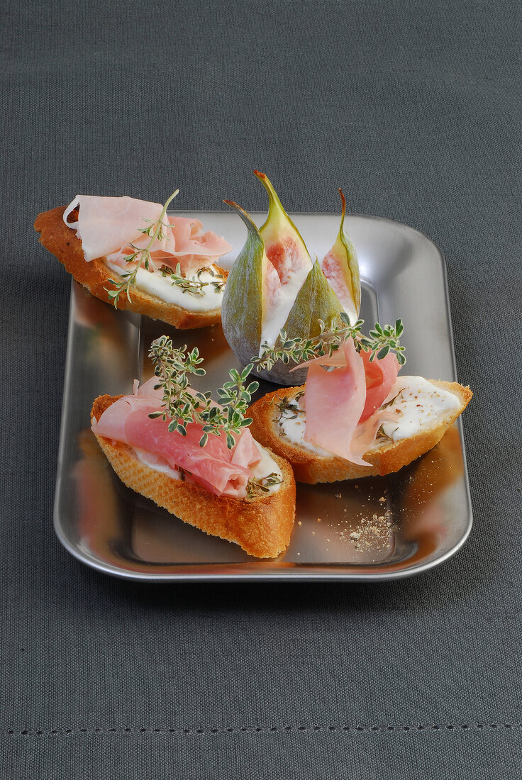 Crostini with cream cheese and ham in serving plate