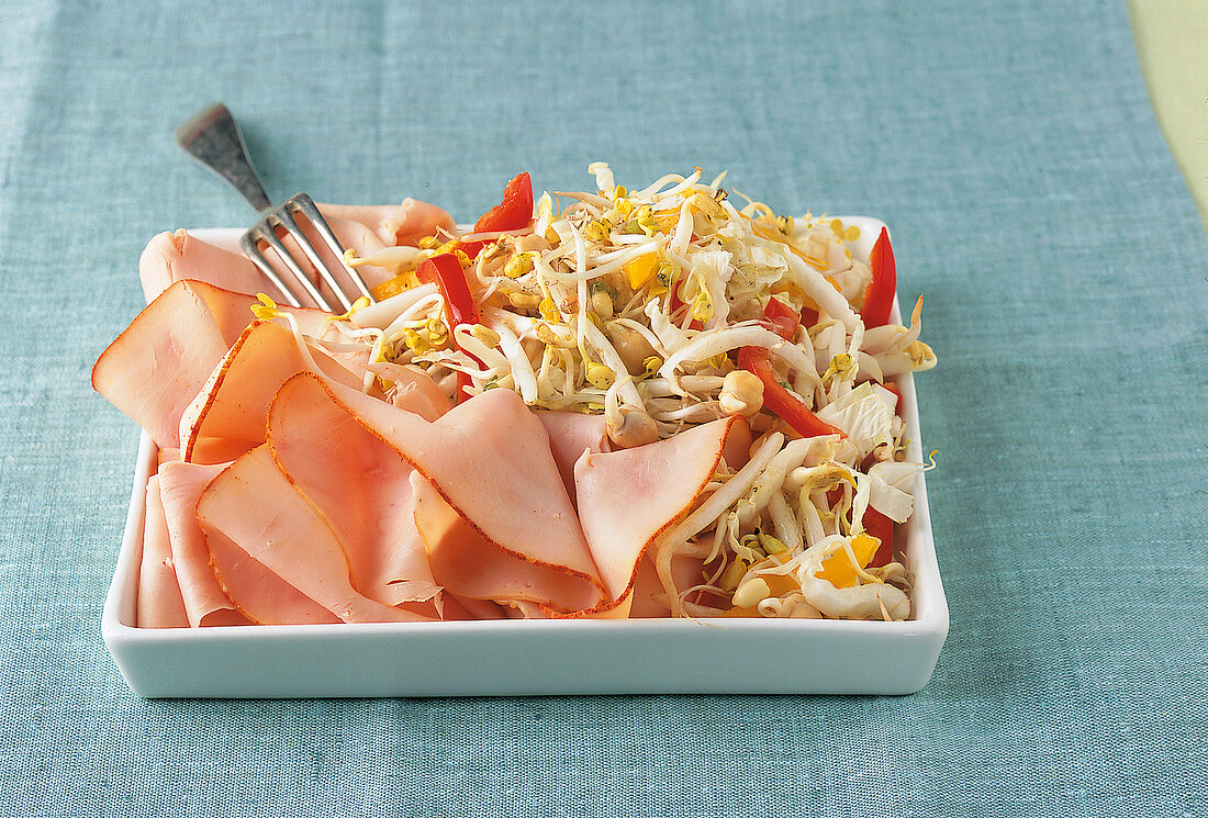 Sprout salad, smoked turkey breast slices in square dish