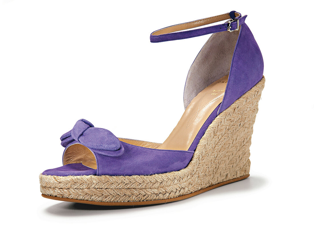 Close-up of purple wedge shoe on white background