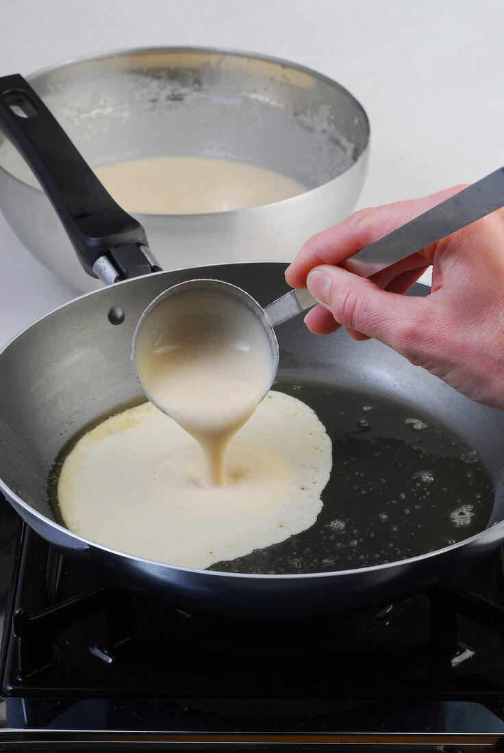 Pancake batter being poured in pan, step 2