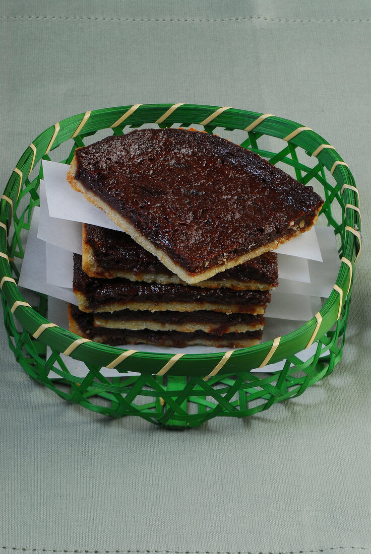 Five pieces of chocolate tart in green wicker basket