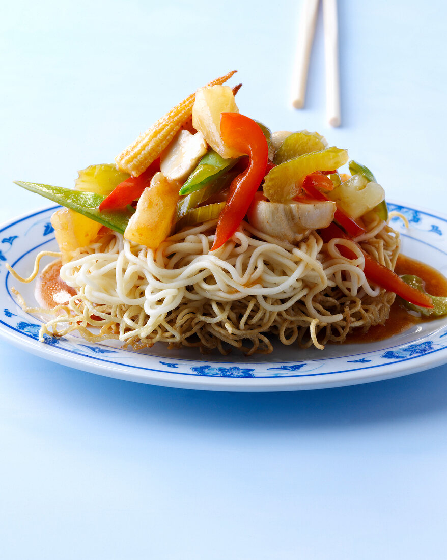 Crisp noodles with sweet and sour vegetables, mini corn and pineapple on plate
