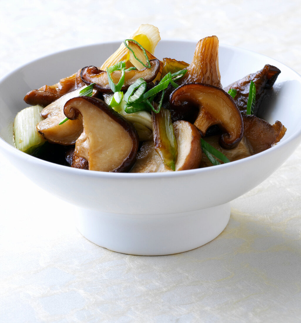 Mushrooms in oyster sauce with spring onions in bowl