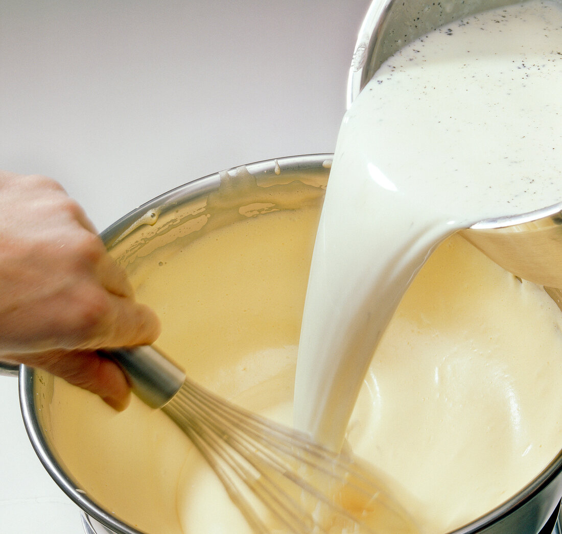 Adding milk mixture to whisked eggs in bowl, step 3