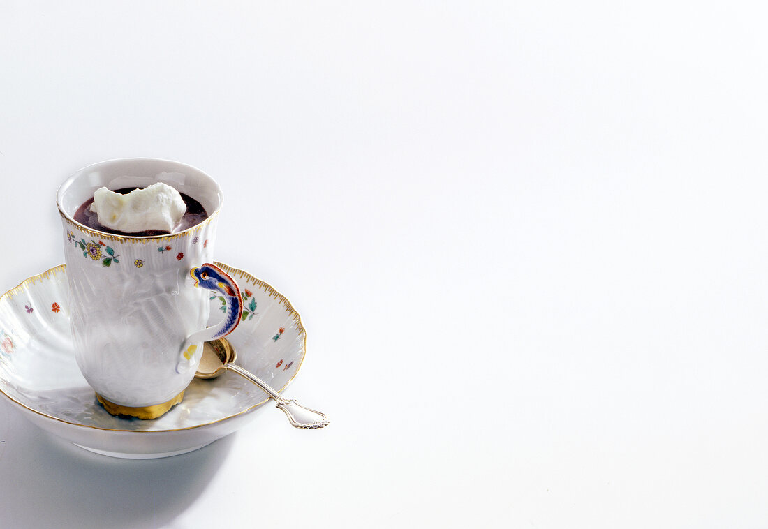 Cup of hot chocolate with whipped cream on white background