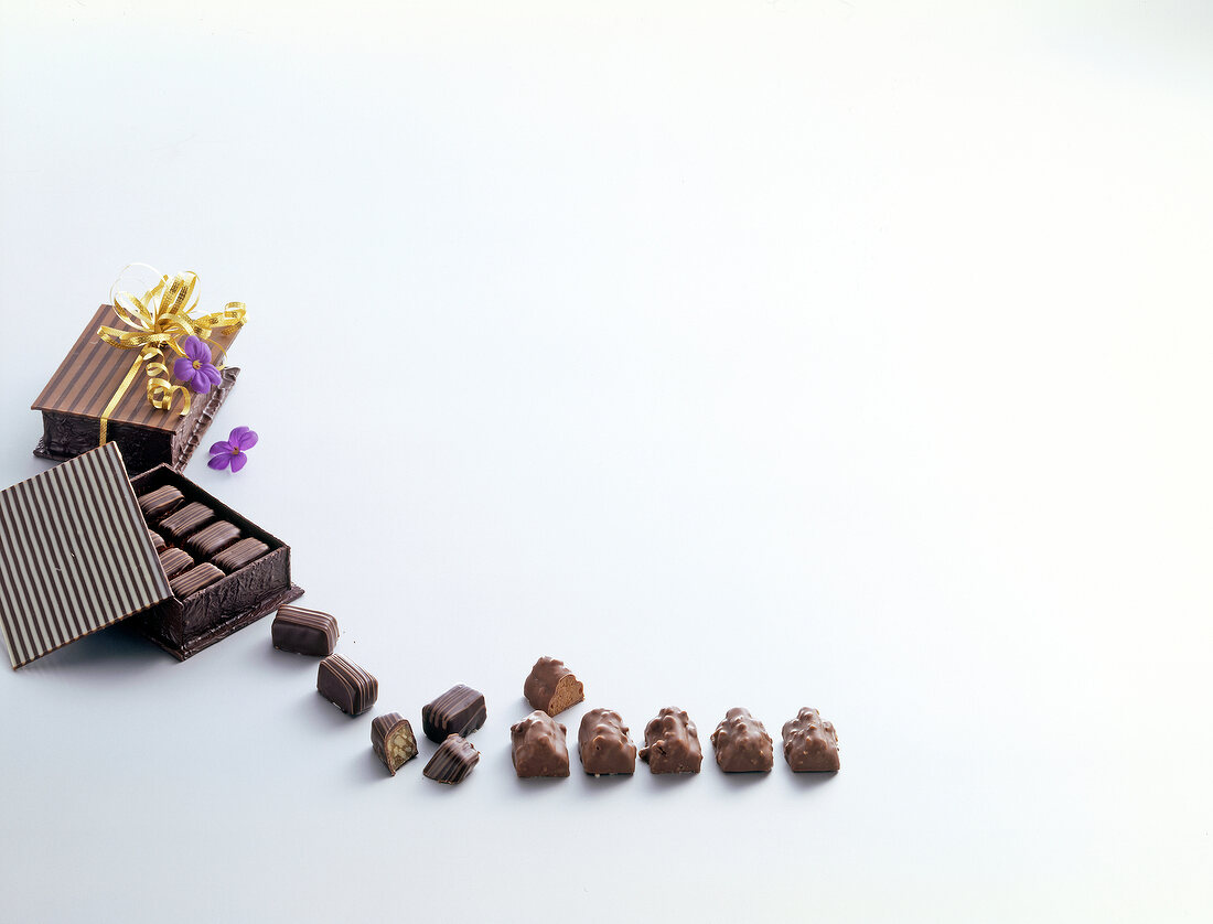 Chocolate candies in candy boxes on white background