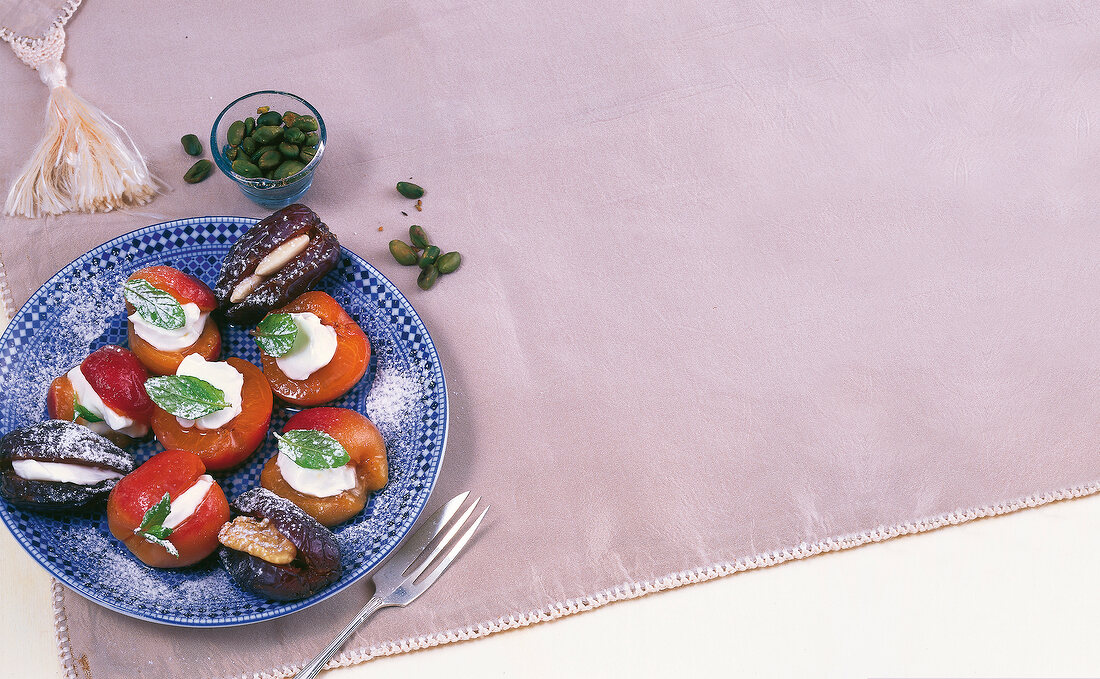 Stuffed apricots and dates with almonds and pistachios on plate