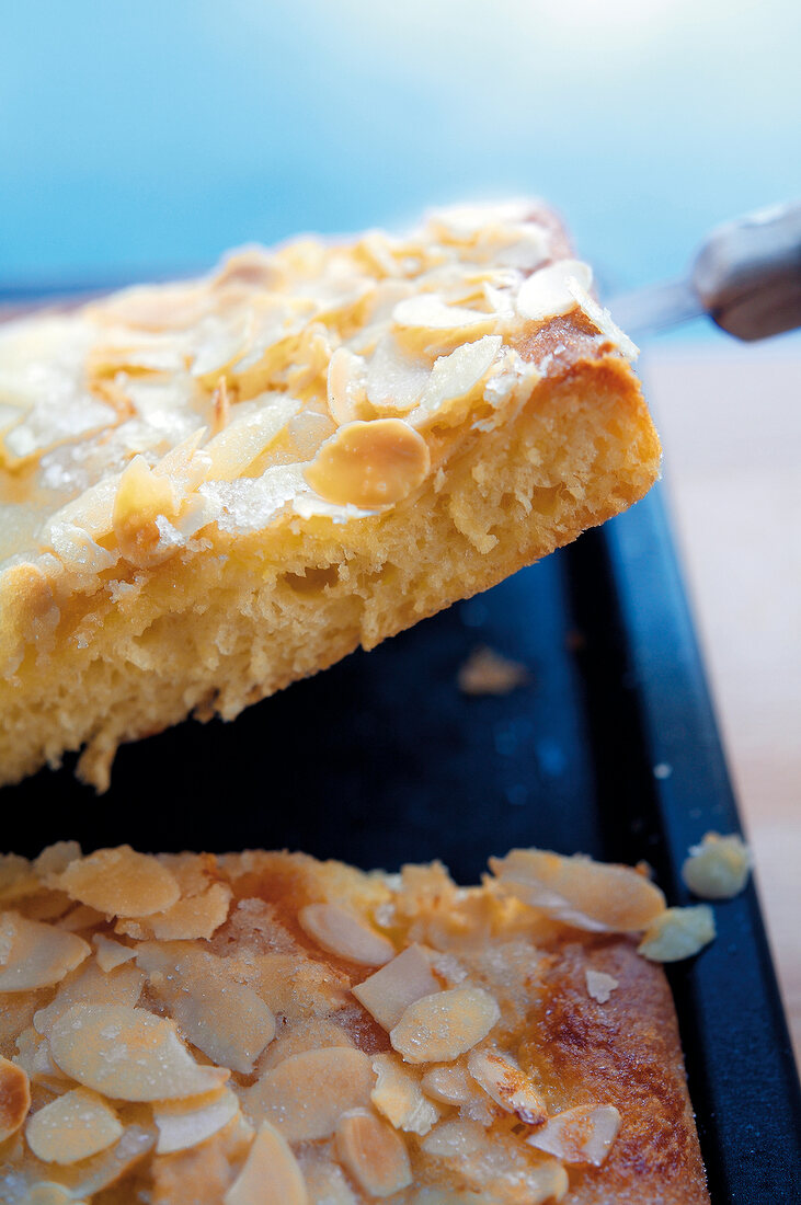 Backen, Butterkuchen vom Backblech heben, Mandelblättchen