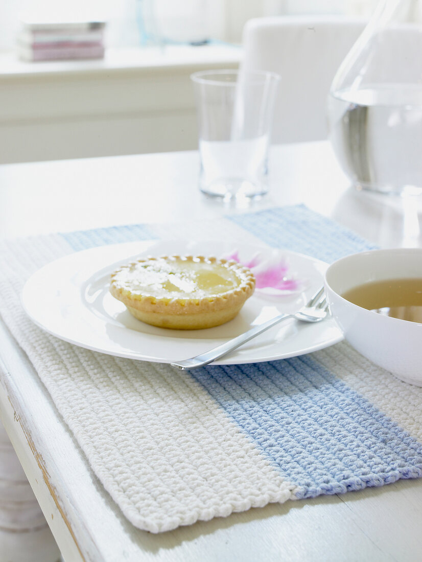 Plate of pastry on white and blue striped crochet table mat