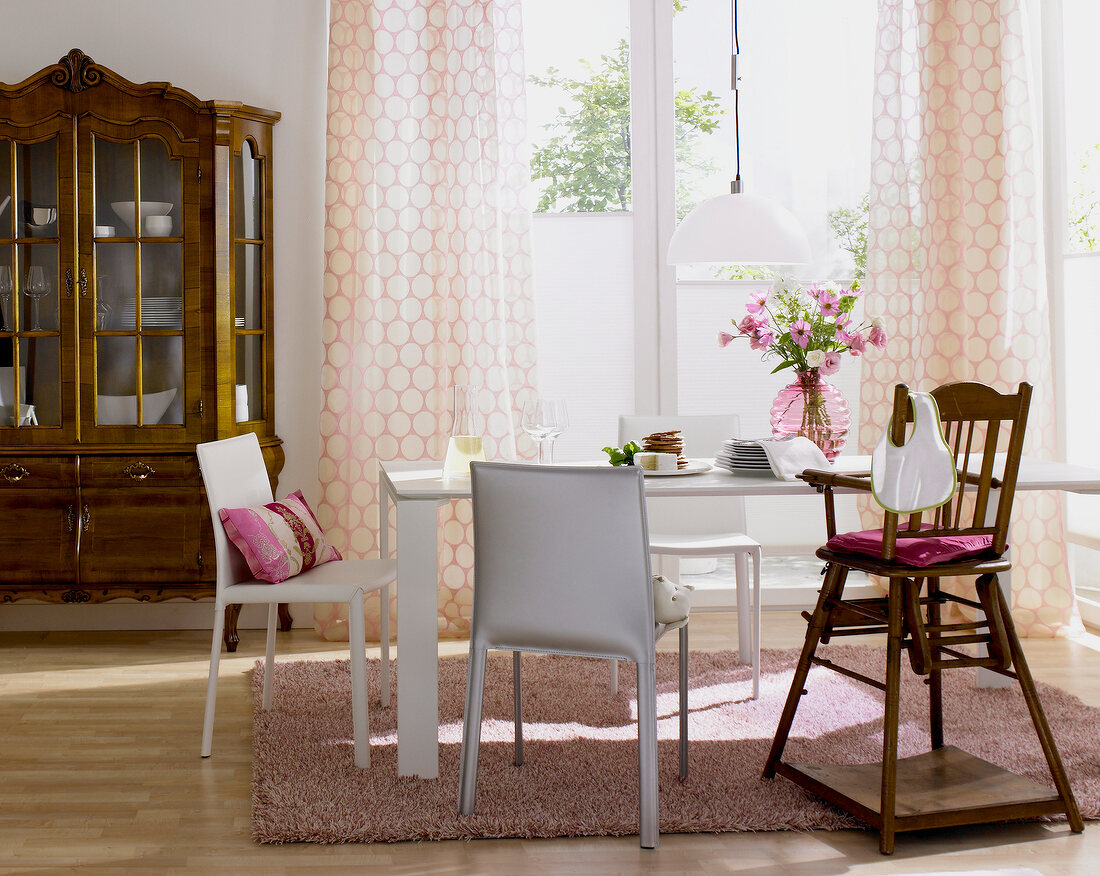 Dining room with table, curtains, white chairs and baroque cabinet