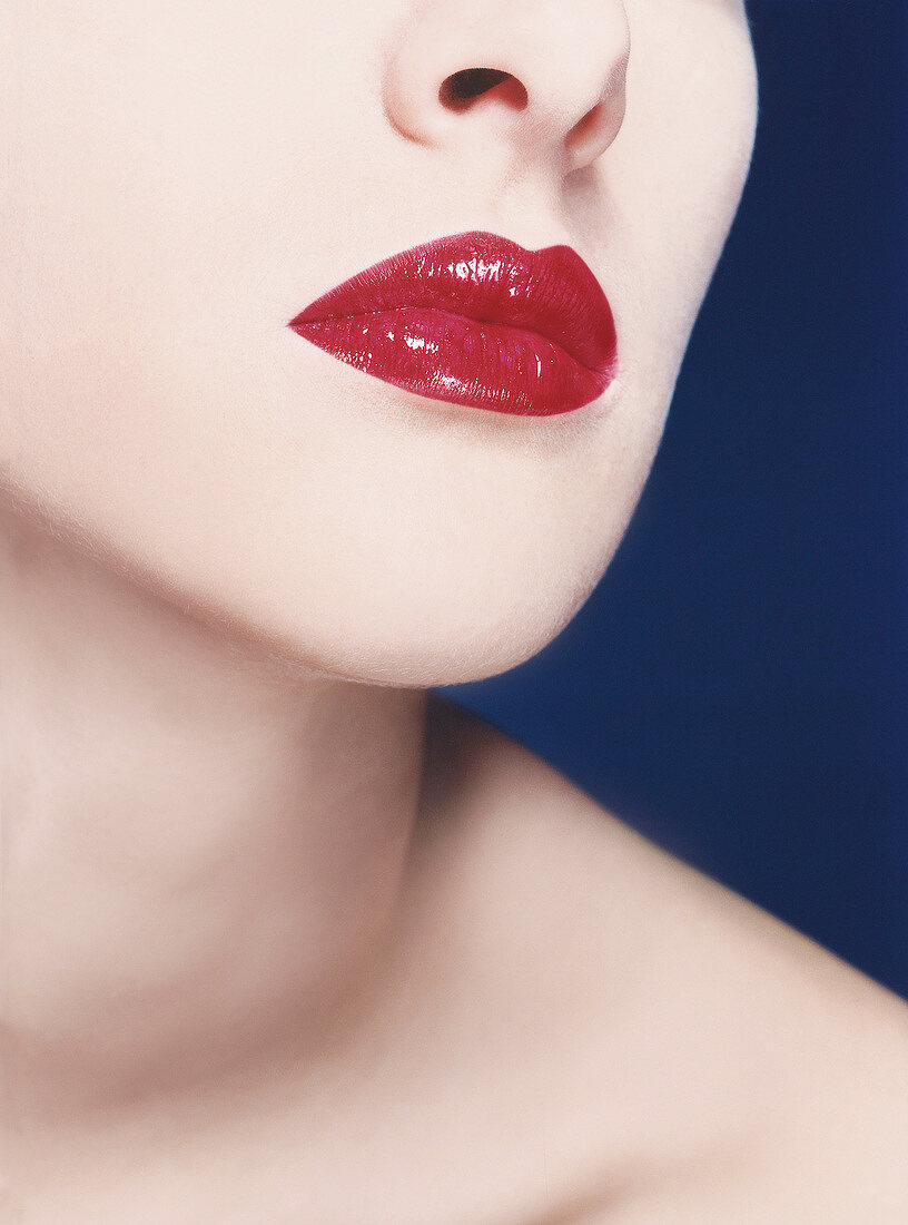 Close-up of woman wearing red lipstick with glitter particles