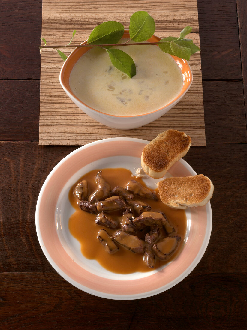 Game meat in dark beer sauce and cider sauce on plate