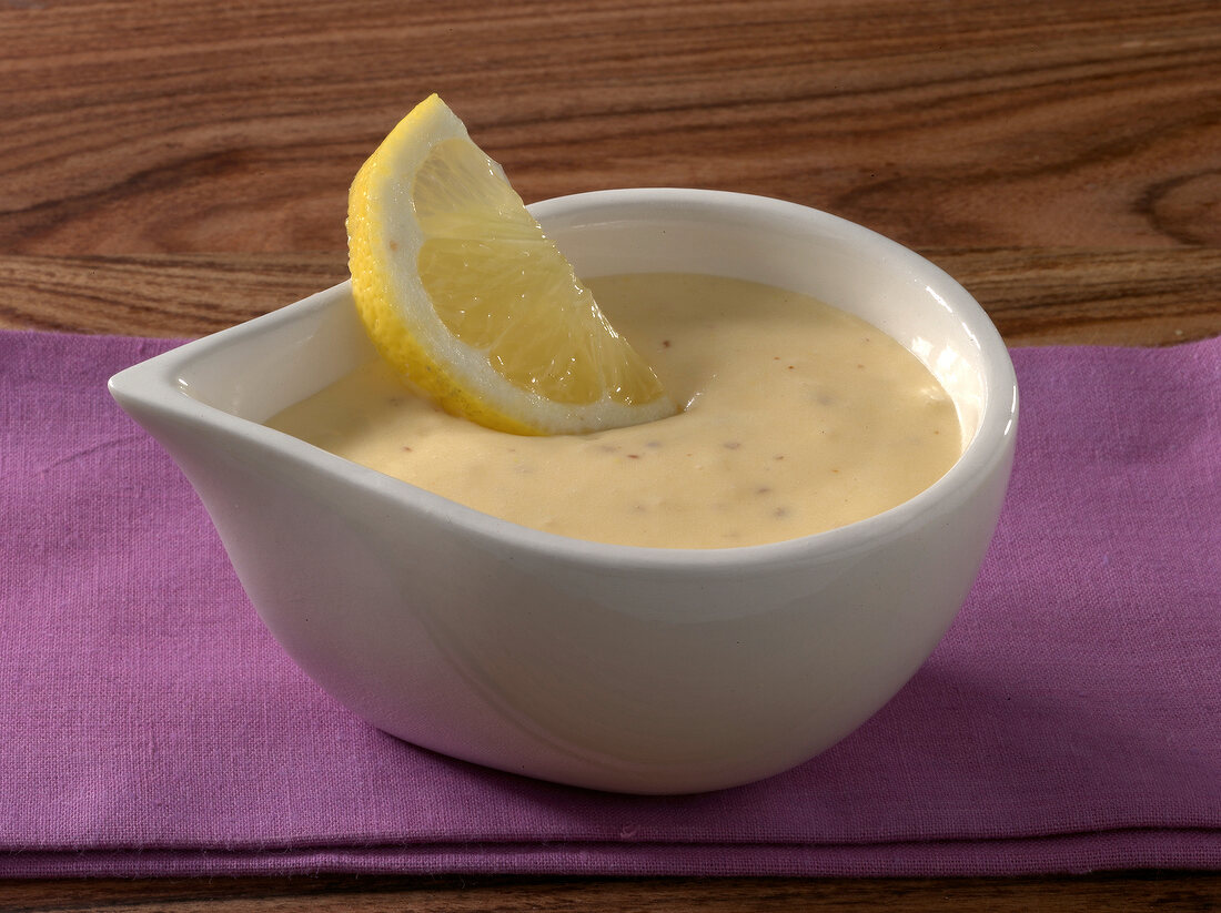 Honey and mustard sauce with lemon slice in bowl