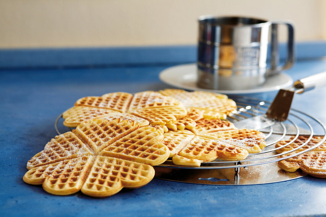 Backen, Waffeln mit Puder- zucker auf Kuchengitter