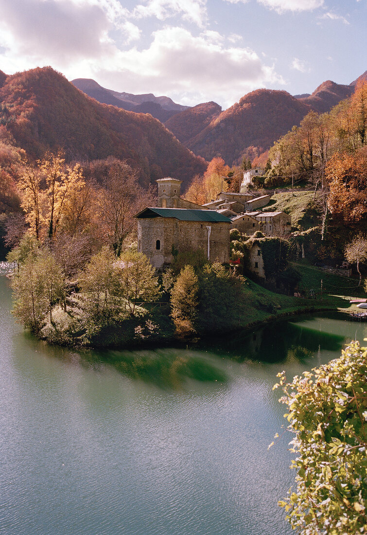 View of Isola Santa with houses, river and mountain ranges in Tuscany, Italy