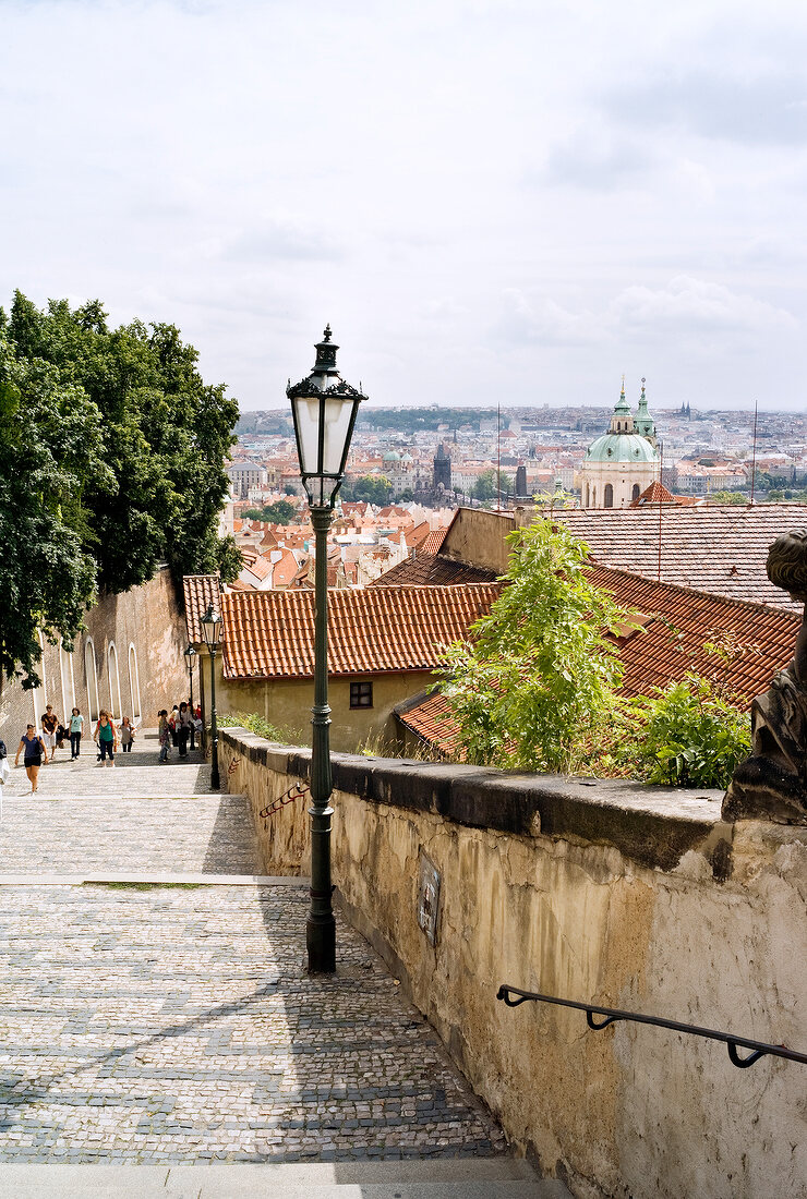 People climbing the steps to Prague castle, view of city in background
