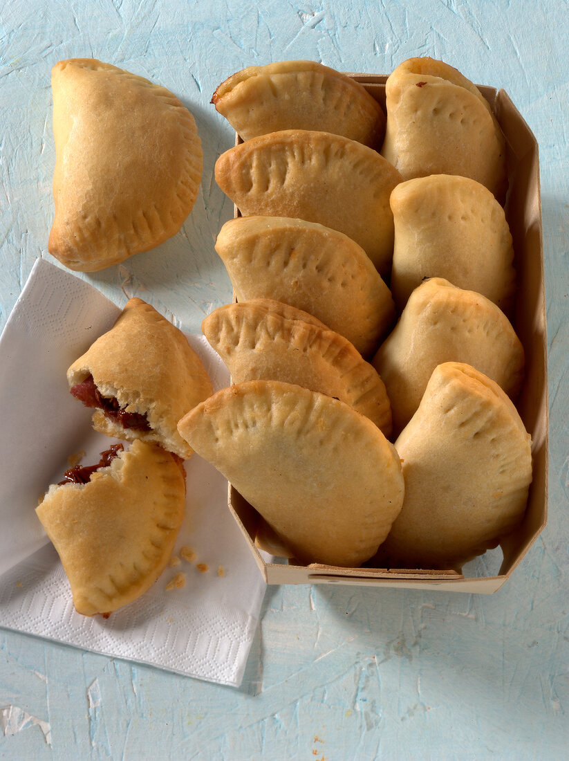 Ten mini calzone stuffed with salami, tomatoes and cheese