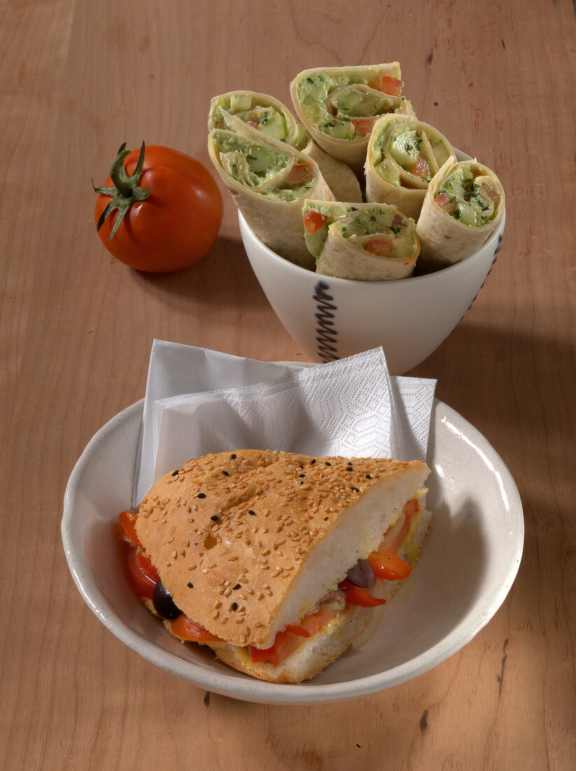 Two bowls of salad wraps and flatbread with tomato filling