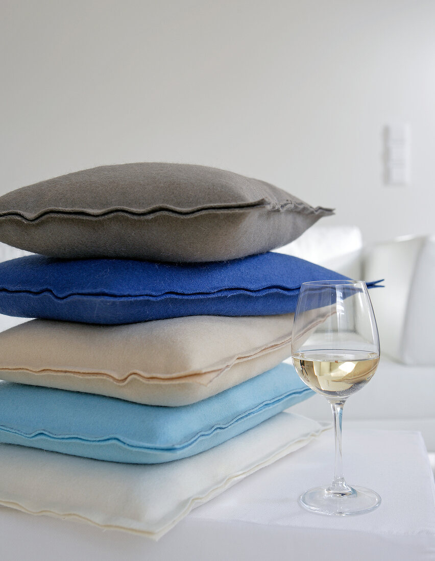 Grey, blue, white and beige cushions stacked on each other