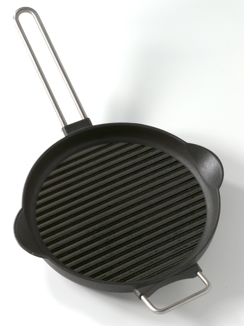 Grill pan made ??of cast iron with handle and webs on white background