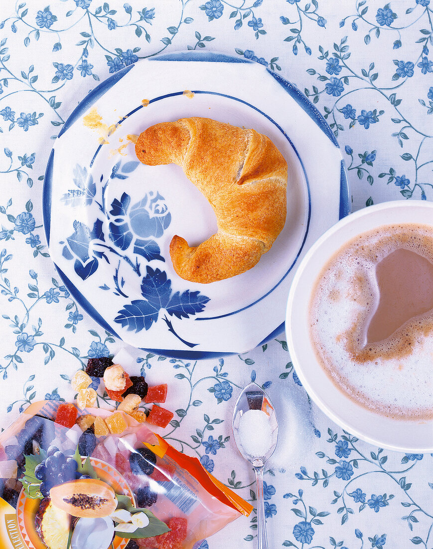 Backen, Croissant mit Fruchtmarzipan und Tasse Milchkaffee