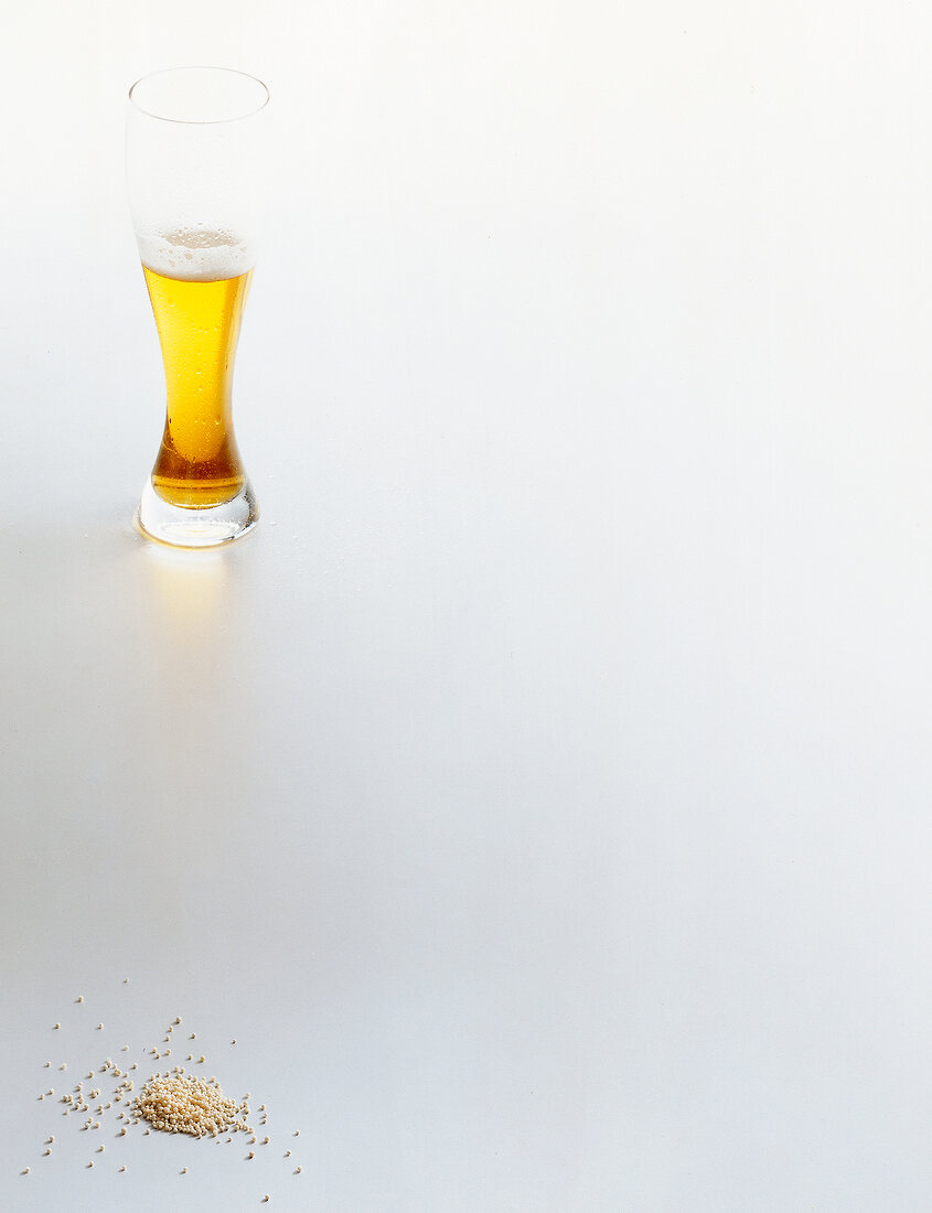 Wheat beer glass and sago grains on white background