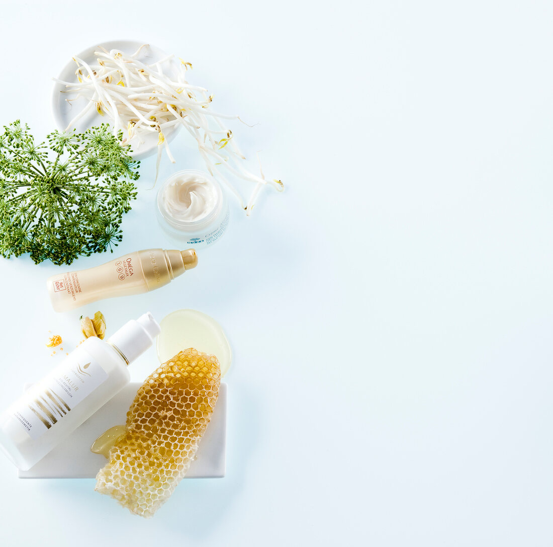 Various toiletries, honeycomb, sprouts, marshmallow on white background, elevated view