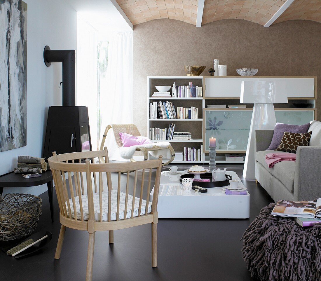 A living room with a brown leather floor, a sofa, a coffee table, a wall unit, a fireplace and an armchair