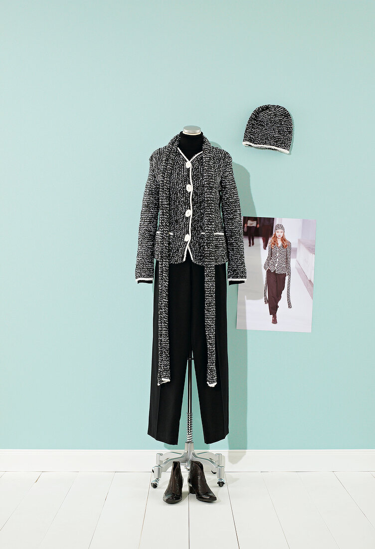 Tweed jacket with scarf and trousers on mannequin, hat and booties on side