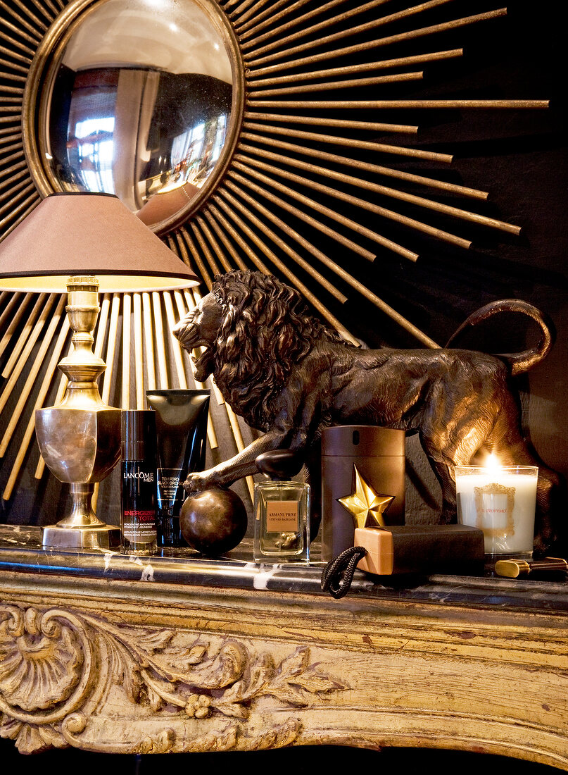 Lion sculpture, lamp post and various men perfumes on gilt tray