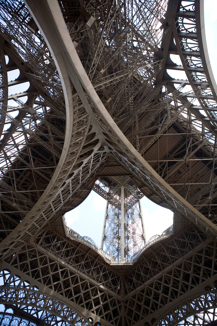 Low angle view of Eiffel Tower with high beams and steel struts in Paris, France