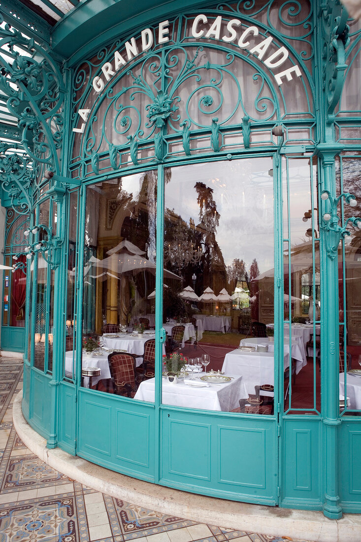 Blick durchs Fenster ins Restaurant "La Grande Cascade", gedeckte Tische