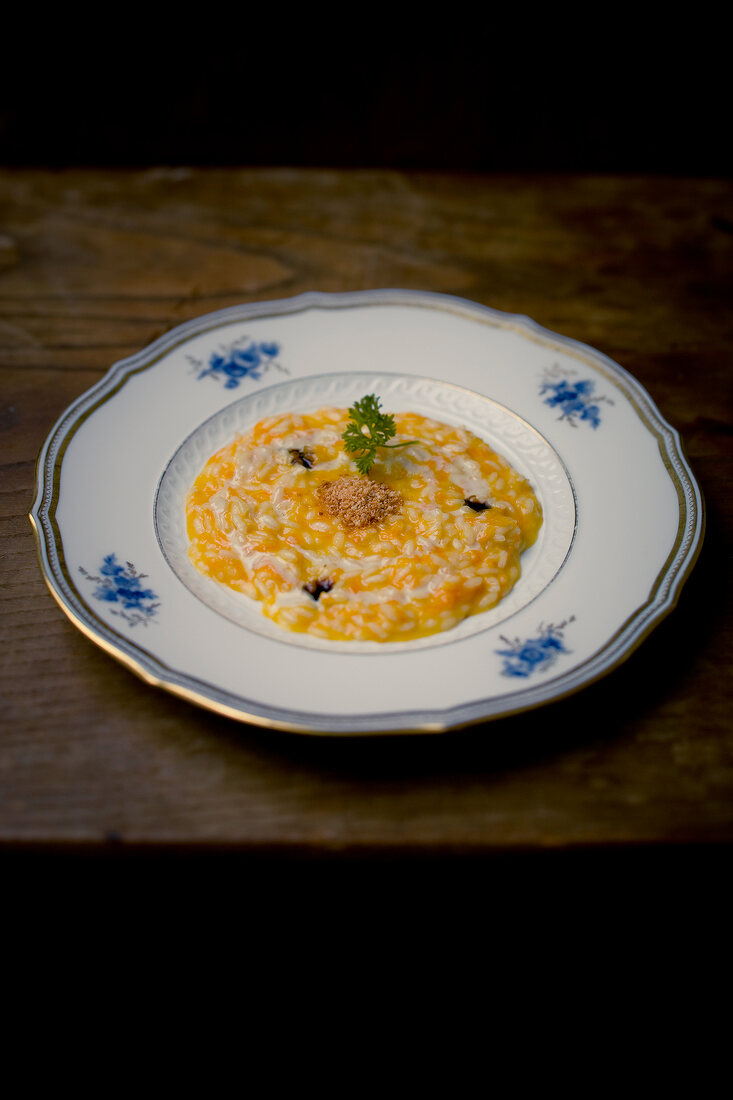 Risotto with yellow pumpkin, amoretti and goat gorgonzola sauce on plate