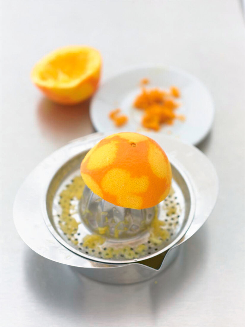 Close-up of orange being squeezed from citrus squeezer