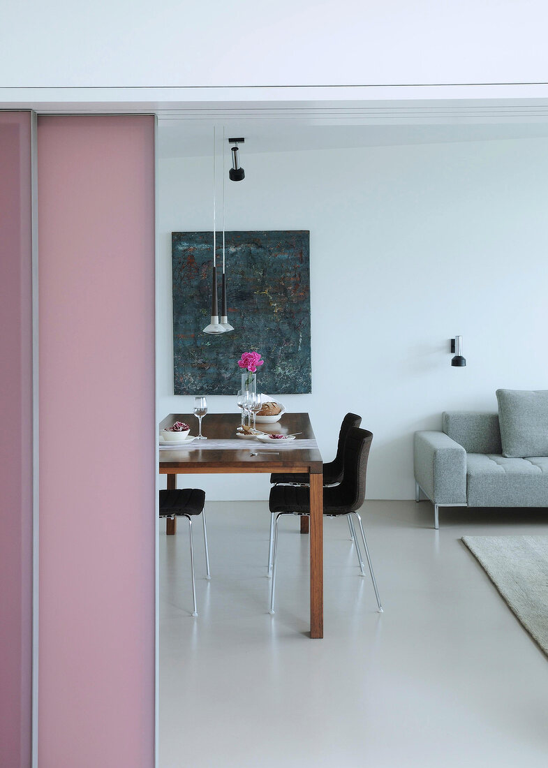 Dining table with dark stools and paintings on wall