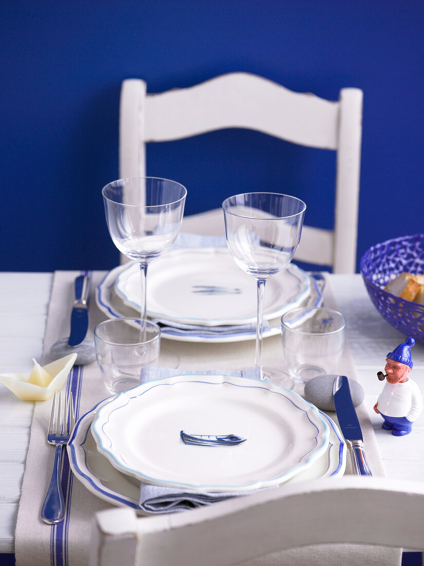 Table laid with wine glasses, glasses, plates and cutlery