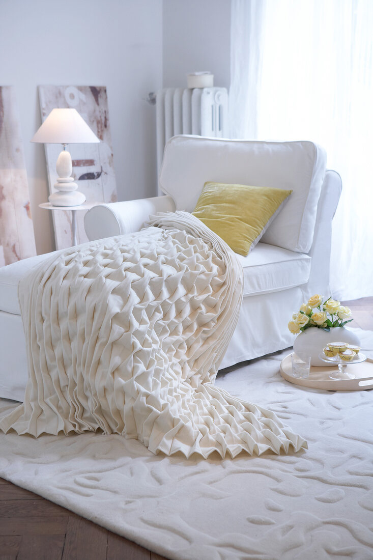 White sofa with white smocked diamond patterned blanket