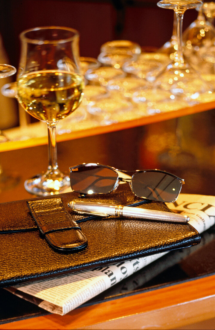 Füllfederhalter und Sonnenbrille auf einer Brieftasche aus Leder