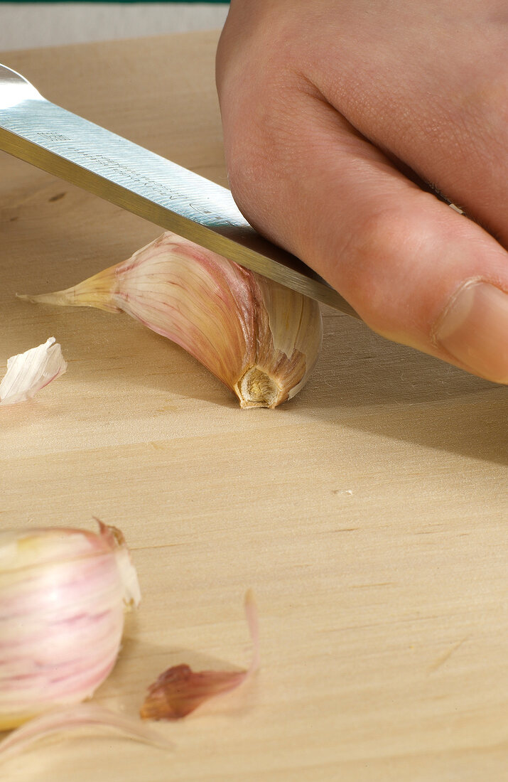 Garlic being smashed with knife, step 1