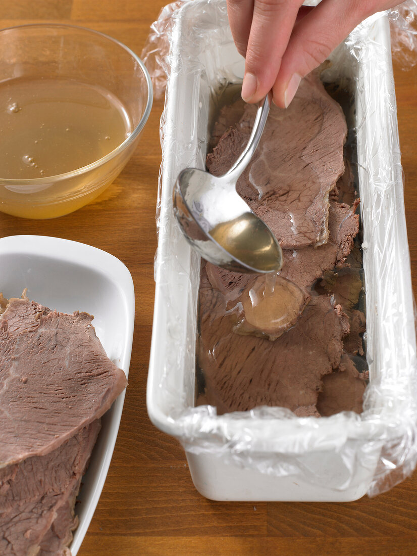 Pouring liquid on boiled beef with ladle, step 1