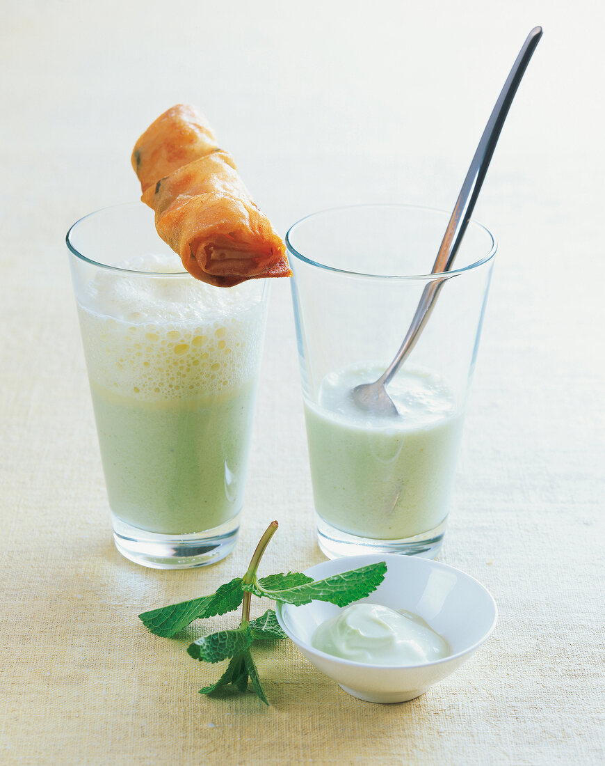 Glasses of cucumber soup with fried seafood and dip