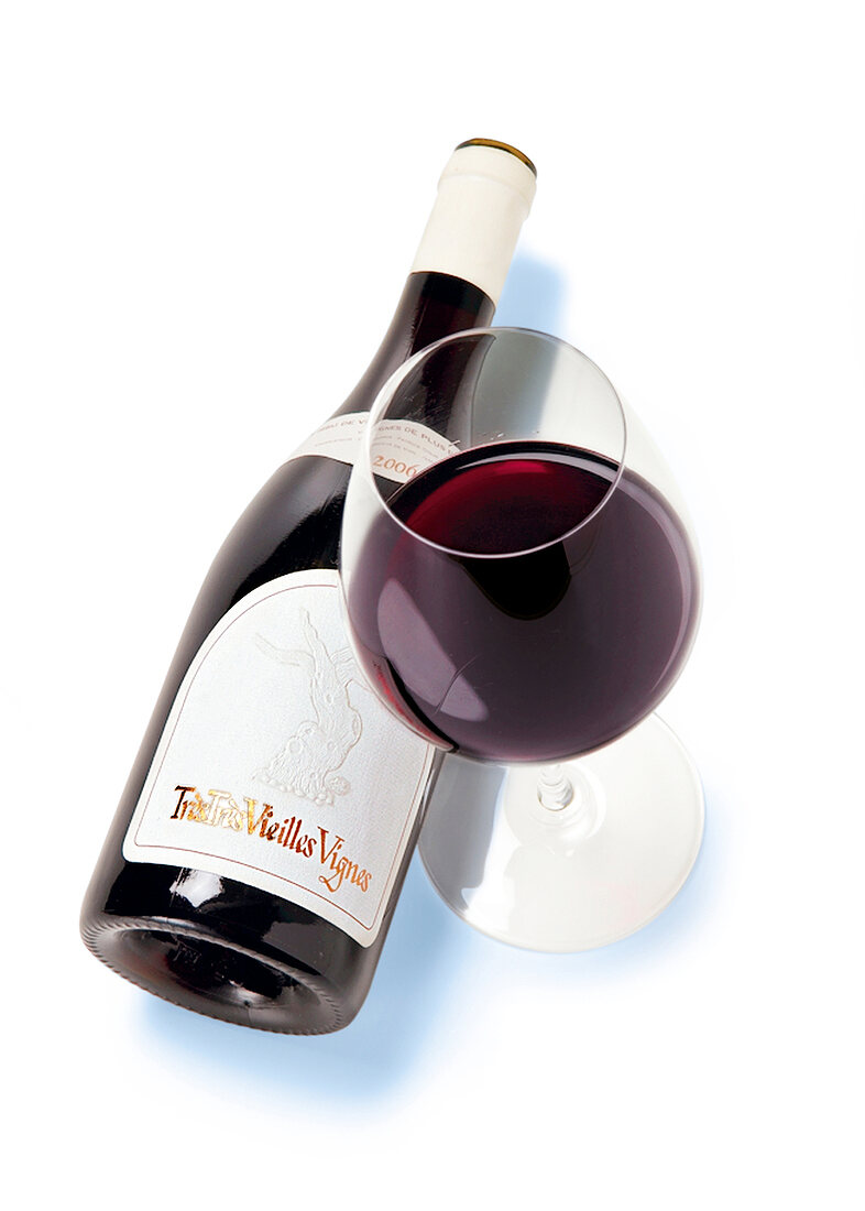 Glass with red wine and bottle on white background
